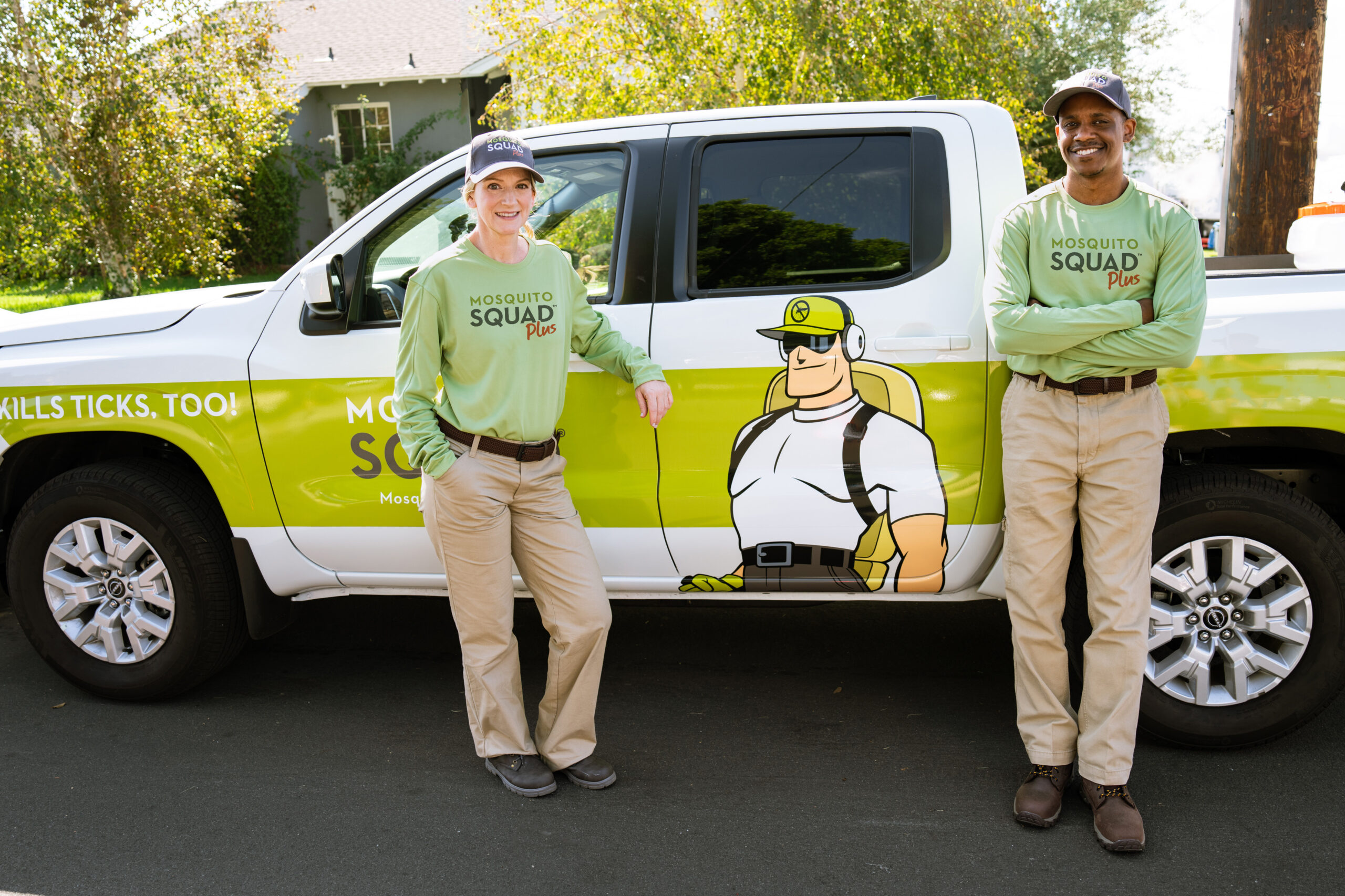 Two owners standing proudly in front of a branded truck